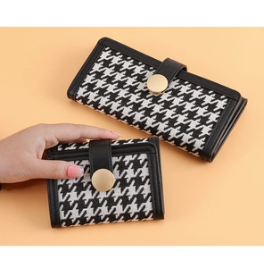Detail of houndstooth long and short wallets with gold buckle and black leather trim