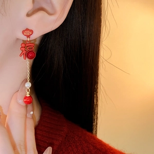 Close-up of new Chinese style pearl earrings with red beads and Fu character on model