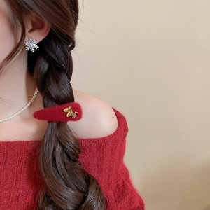 Detail of red plush hair clip with gold rocking horse and silver snowflake studs
