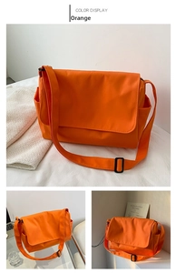 Detail view of large orange oxford crossbody bag showing side pockets and adjustable strap