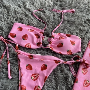 Detail of pink strawberry print bikini with mesh skirt fabric and care label information
