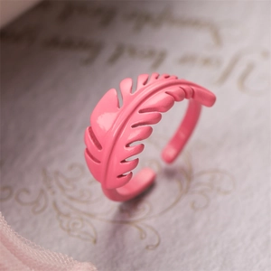 Macro shot of pink feather-shaped lacquer ring with soft textures and metallic finish