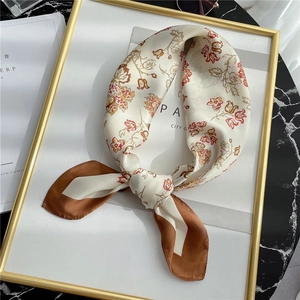 Close-up of floral print silk scarf featuring retro patterns and smooth satin texture