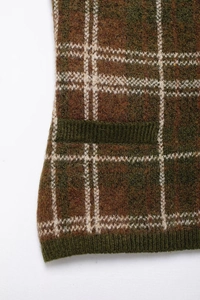 Detailed macro view of the vintage brown and green checkered knit texture and side pocket