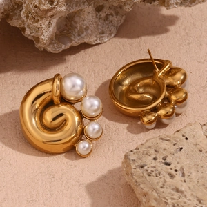 Detailed view of 18K gold plated spiral earrings with elegant pearls on natural stone
