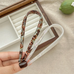 U-shaped acetate hair pins in tortoiseshell and pearl white with French lettering