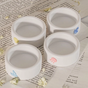 Set di quattro stampi in silicone bianco per candele con icone colorate a rilievo su giornale