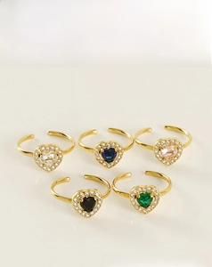 Detail of five 18K gold plated heart rings with colorful zircon stones in a set