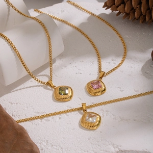 Detailed close-up of three gold square zircon necklaces with vintage striped lace edges