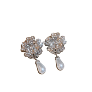 Parure trèfle à quatre feuilles avec cristaux brillants et perles gouttes sur fond blanc