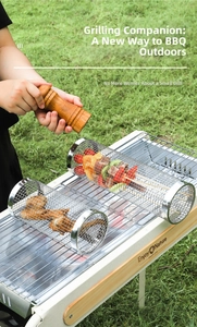 Close-up of portable stainless steel rolling grill basket on fire with meat and veggies