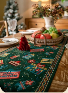 Detailed embroidery of Merry Christmas text and holiday motifs on green table runner fabric