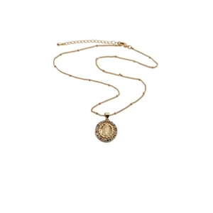 Detail of gold Virgin Mary pendant with colorful cubic zirconia on a ball chain