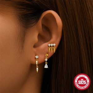 Trois boucles d'oreilles en argent S925 doré avec zircons étincelants sur l'oreille