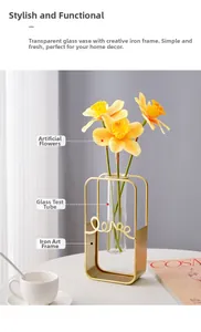 Close-up of golden iron love frame with glass test tube vase and yellow daffodils