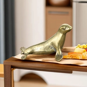 Detail of vintage brass seal figurine with antique bronze texture on a wooden desk
