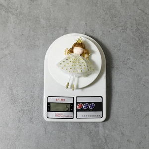 Detail showing a 5g lightweight Christmas angel ornament on an electronic scale