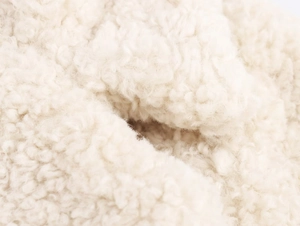 Detailed macro view of soft white faux fur texture on a plush fleece coat fabric