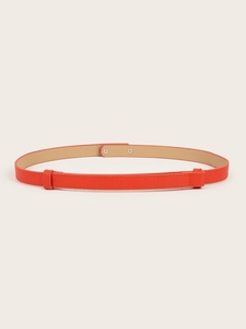 Close-up of orange Saffiano leather skinny belt with elegant cross-hatch texture and loops