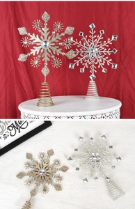 Dettaglio di puntali per albero a stella glitterati in oro e argento con pietre colorate