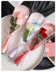 Detail of assorted artificial rose bouquets in pink and blue with romantic floral wrapping