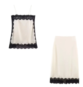 Detail of silk-satin camisole and skirt set with black lace trim on cream fabric