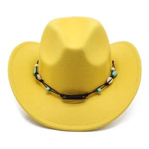 Detail of yellow wool fedora hat featuring western beads, shells and woven black string