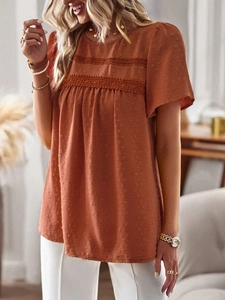 Detail of brick red short sleeve blouse with dot texture and white lace trim accents