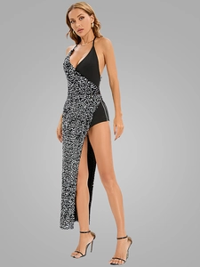 Detailed view of high slit asymmetric dress with black and silver sequins and halter neck
