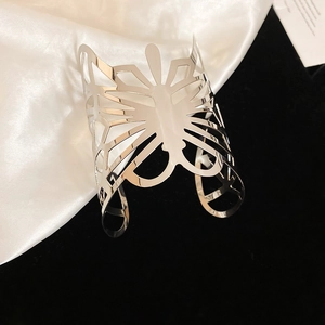 Primer plano del brazalete de mariposa calada plateada con textura plisada