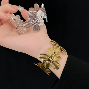Macro shot of vintage metal flower bracelets in gold and silver with brushed texture