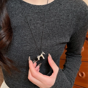 Détail du pendentif poney argenté sur collier cordon noir porté par un mannequin