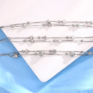 Detailed close-up of double-layer silver star bracelet with polished and frosted beads