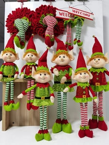 Detailed view of plush Christmas elves with red and green striped stockings and Welcome sign