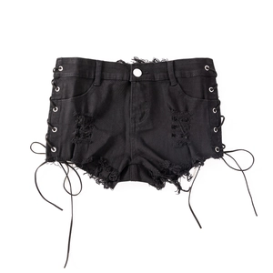 Detailansicht der schwarzen Denim-Shorts mit Rissen und seitlicher Schnürung mit Metallösen