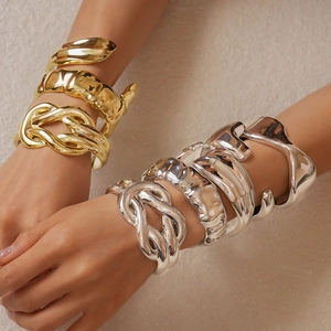Chunky twisted gold and silver cuff bracelets with an organic molten metal texture