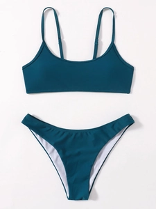 Flat lay detail of dark teal two-piece bikini with high-waist bottoms and thin straps