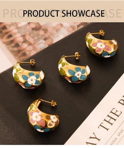 Detailed macro view of four C-shaped gold-plated earrings with colorful enamel floral patterns