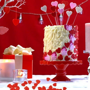 Red and pink heart confetti and cake toppers for Valentine party table decorations