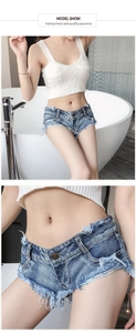 Detail der Vintage blauen Denim Hotpants mit ausgefransten Kanten und Metallknopf