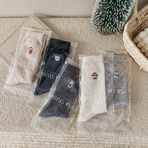 Gros plan de cinq paires de chaussettes de Noël avec broderies sur tissu côtelé