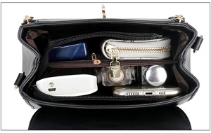 Interior view of black soft leather crossbody bag with multiple compartments and gold hardware