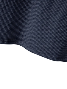Close-up of navy blue waffle knit fabric showing double-needle hem stitching detail