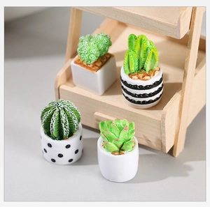 Detailed view of four miniature succulent resin models with striped and dotted plant pots