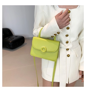 Detail of light green PU leather handbag featuring a stylish gold circular ring buckle