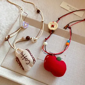 Handmade fabric coffee cup and red apple pendant necklaces with colorful beaded accents