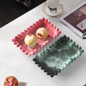 Detailed view of rectangular bubble-edge trays with marble textures in red and dark green