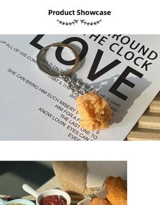 Realistic fried chicken wing keychain with metal ring on a rustic wooden tabletop