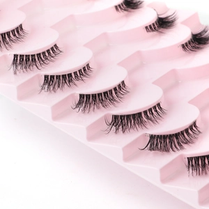 Detailed view of 8 pairs of natural wispy false eyelashes on a pink tray display