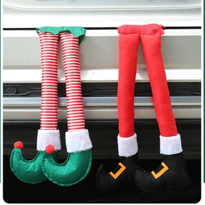 Christmas elf legs decor hanging from car trunk featuring red and green festive stripes